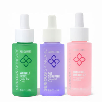 Three bottles of Serious Skincare Absolutes on a white background.  Wrinkle Rebel.  Ferulic Acid.  Vitamin C + E.  Age Disrupter.  Resveratrol Burst.  Moisture Multiplier.  4D Hydration Intensifier.  