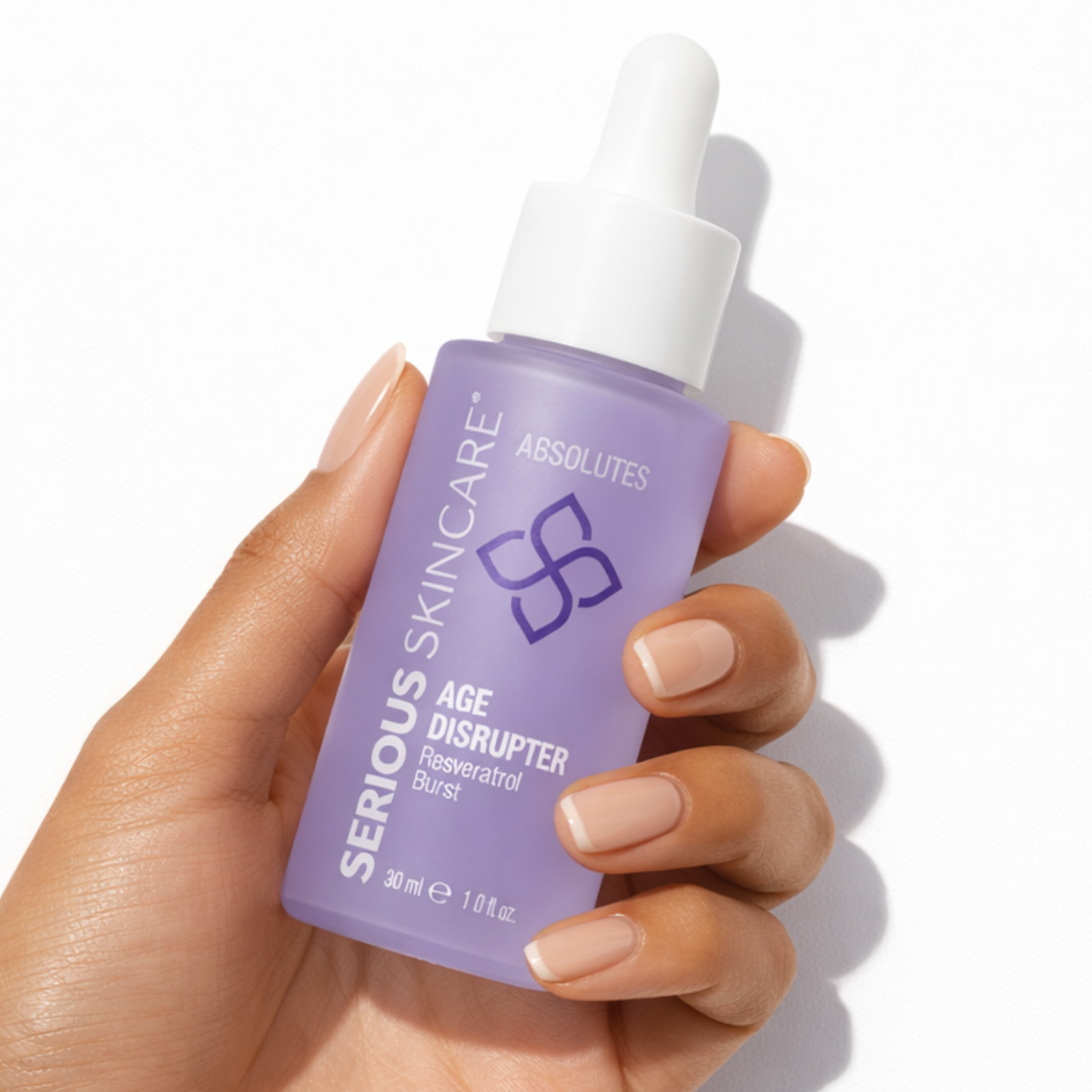 Hand holding a bottle of Serious Skincare Absolute Age Disrupter on a white background