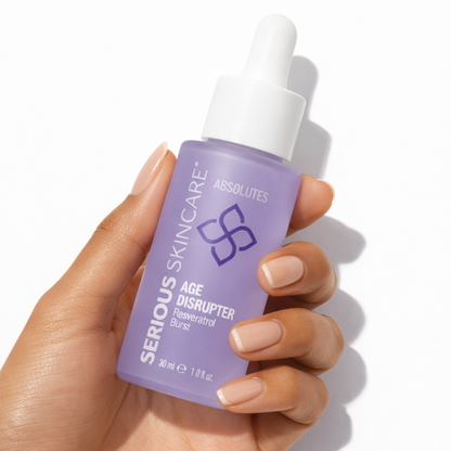 Hand holding a bottle of Serious Skincare Absolute Age Disrupter on a white background