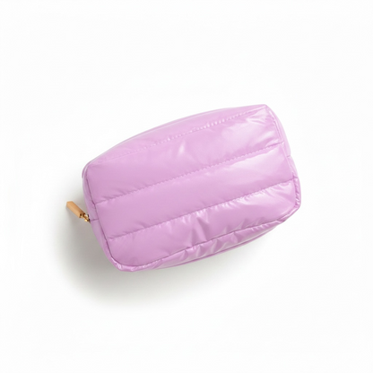 Pink quilted pouch with a gold zipper on a white background