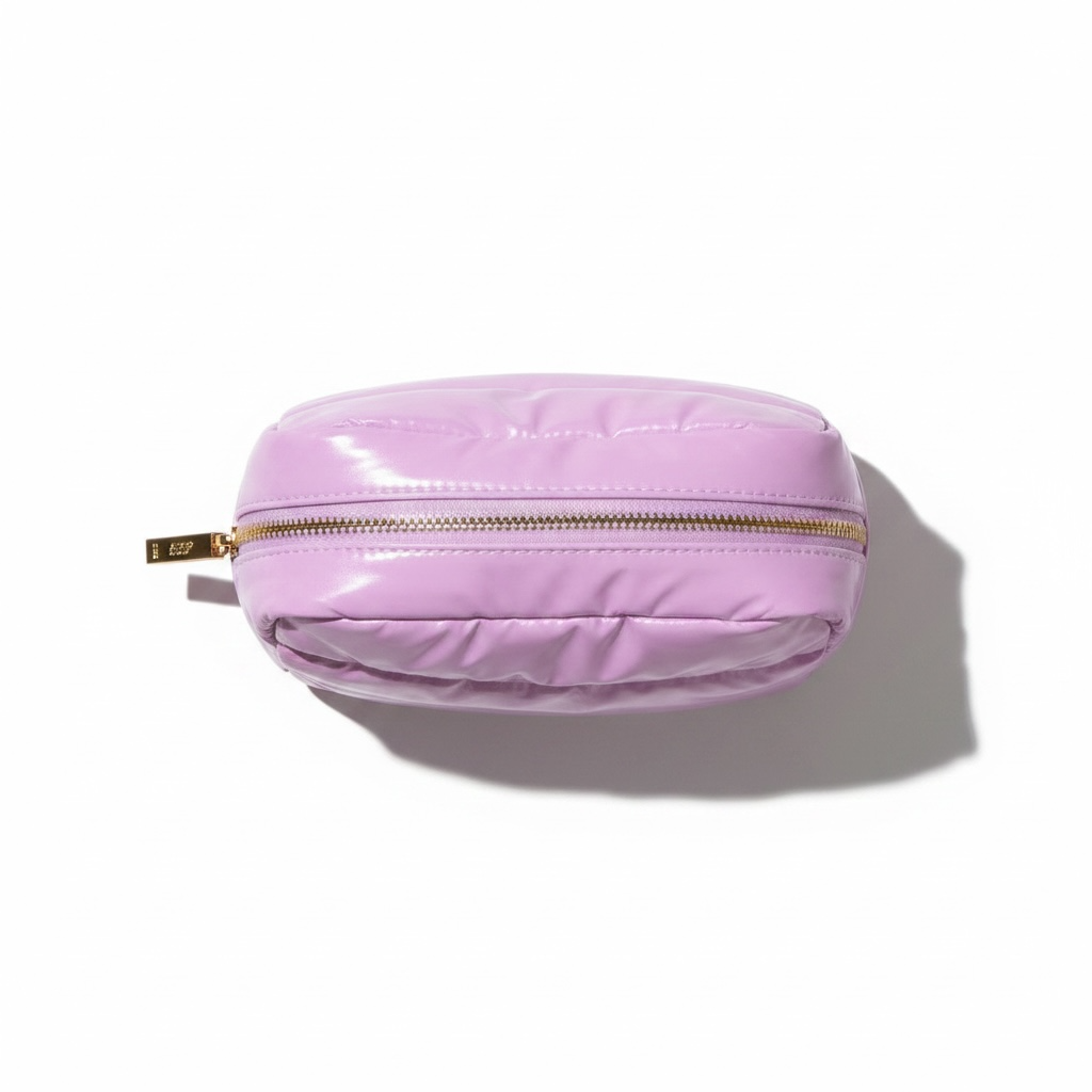 Pink quilted pouch with a gold zipper on a white background